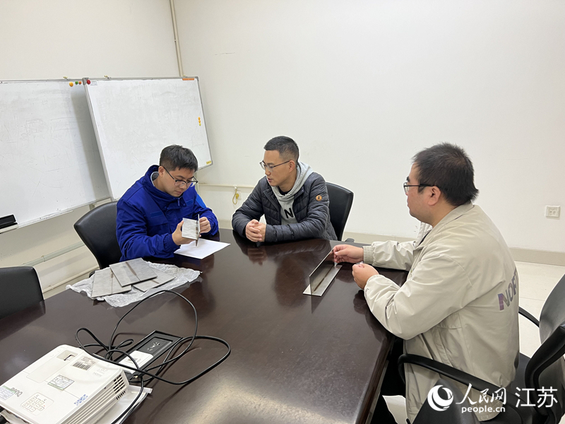 张涛（中）和企业沟通技术细节。人民网 江楠摄